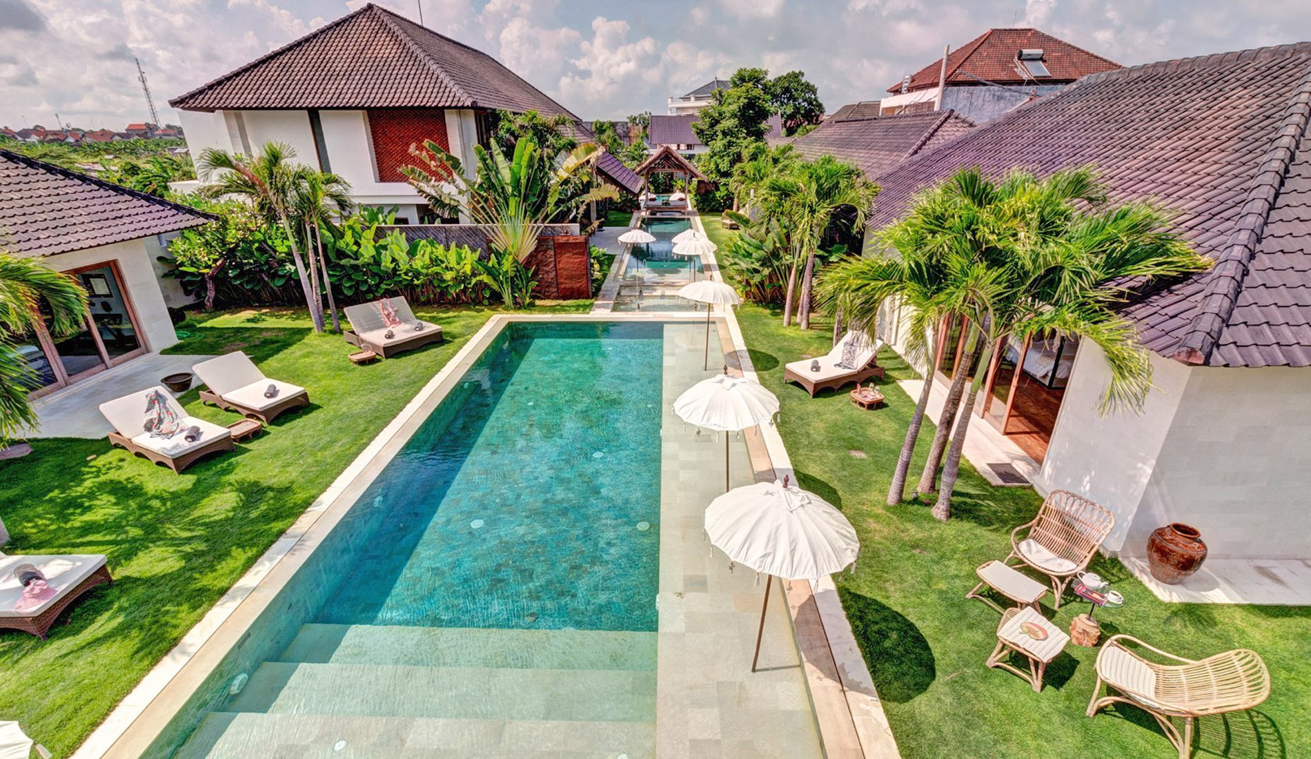 Elevated view over the pools, lawns and three villas of the Abaca Villas estate in Seminyak
