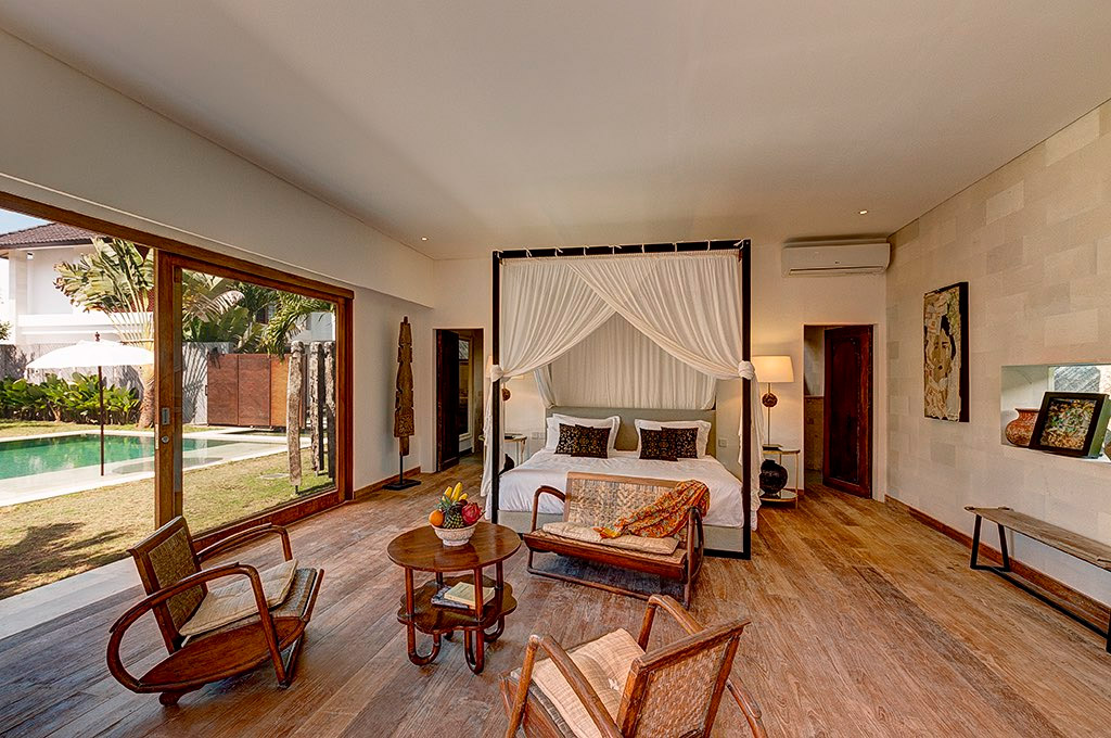Four-poster bedroom opening onto the pool and garden at Abaca Villas, Seminyak
