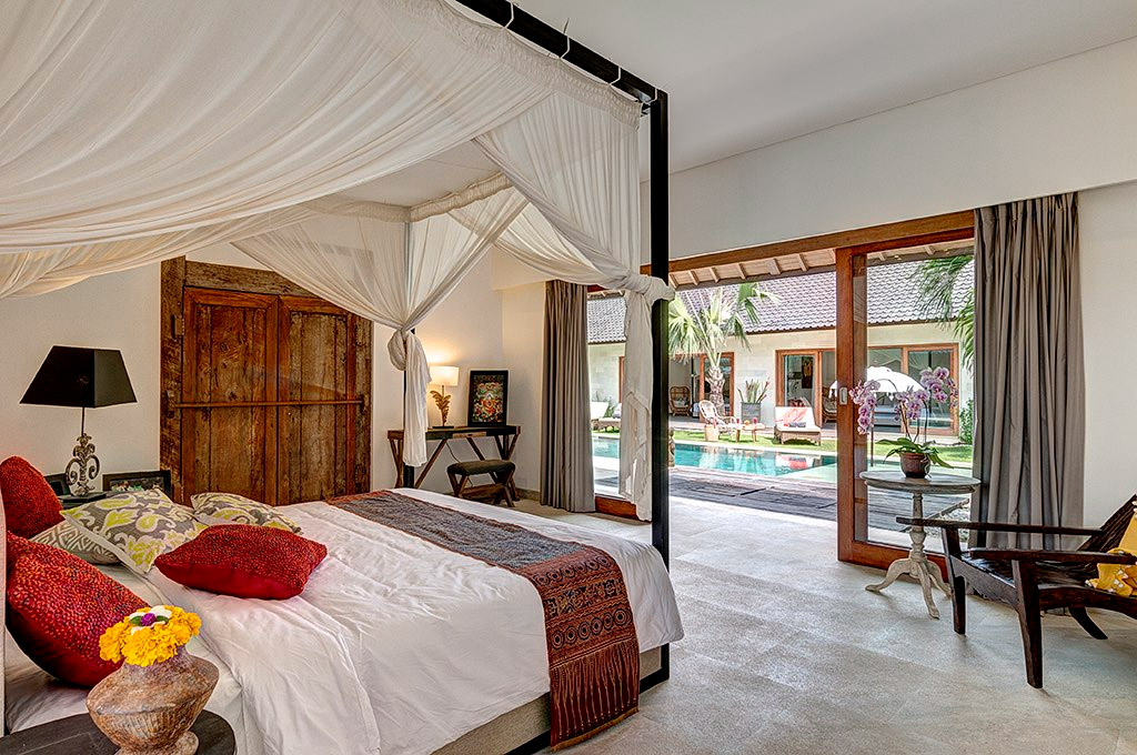 Master bedroom with canopied bed sliding open to the poolside at Abaca Villas, Petitenget, Seminyak