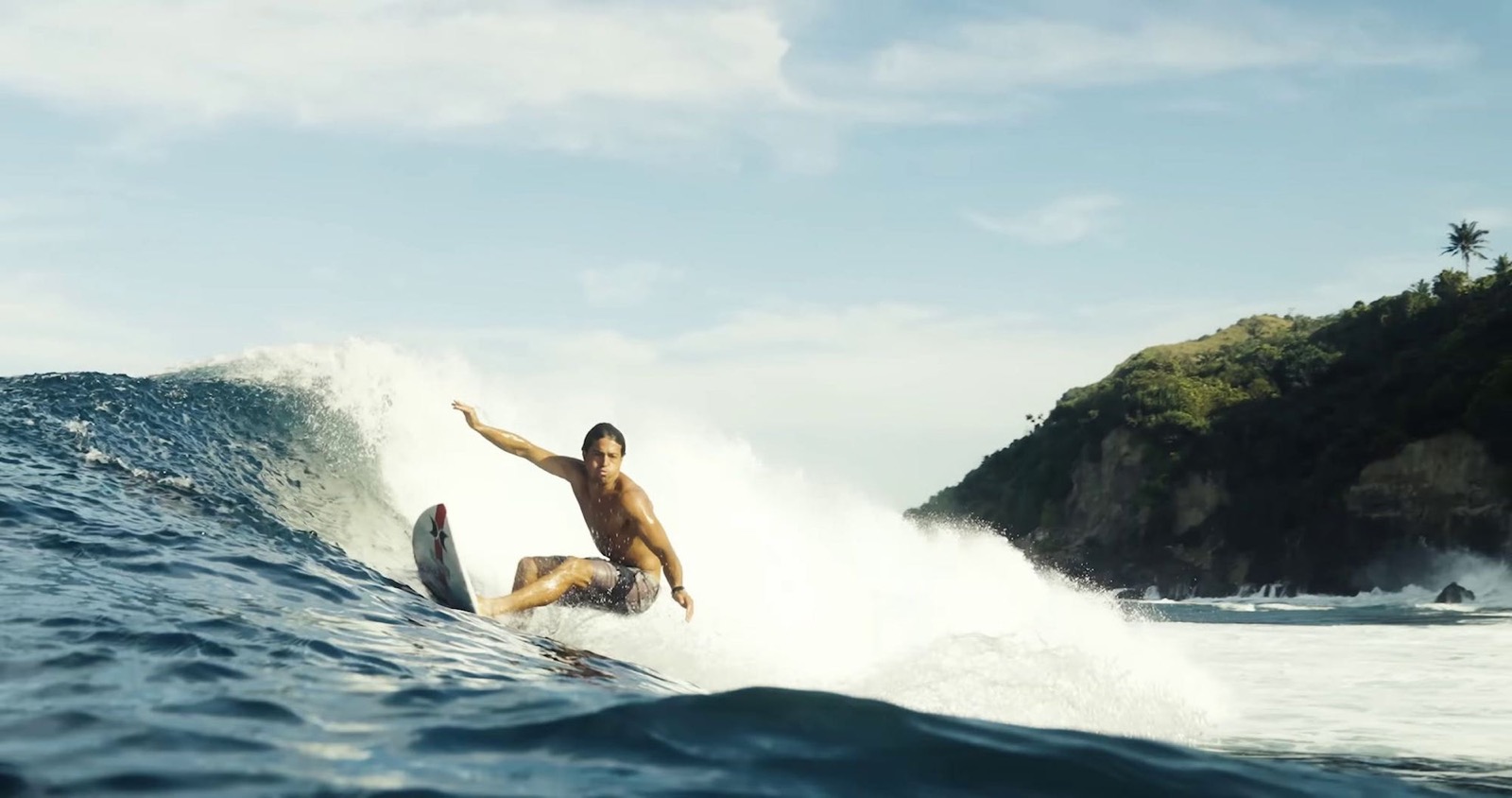 A surfer riding a clean wave off the Lamboya coast in front of Alamayah, Sumba