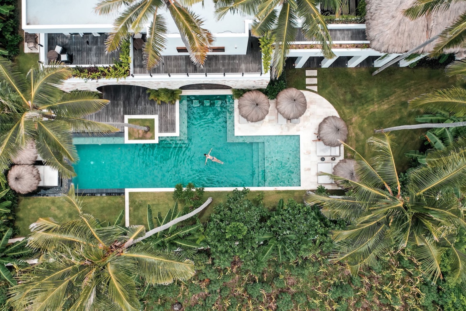 Aerial view looking down on the pool, thatched parasols and palm gardens of Alamayah at Lamboya on Sumba, one flight from Bali