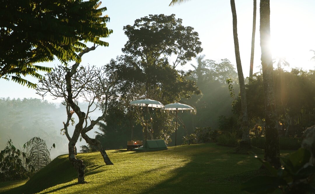 Lawn pavilions at sunrise with valley and morning mist, Amandari, Ubud