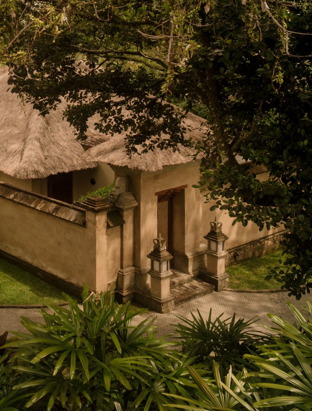 Villa building with thatched roof nestled among tropical plants, Amandari, Ubud