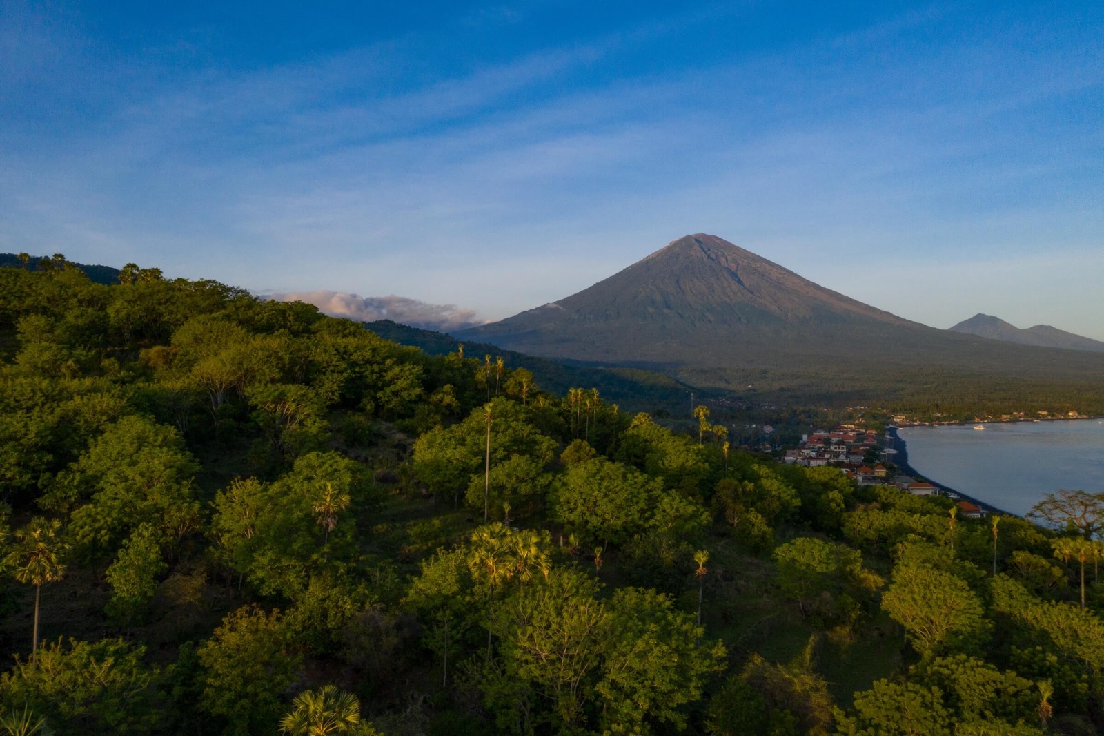 Mount Agung rising above the coast and village at Amed in east Bali, seen from the hills behind Amed Lodge by Sudamala Resorts