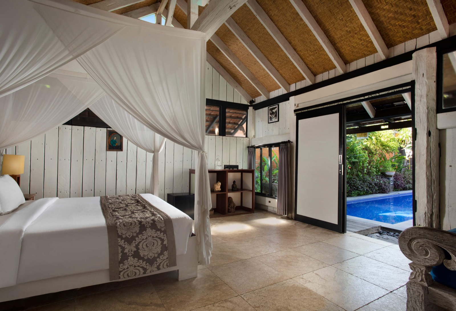 Cottage with a four-poster mosquito net opening onto the pool at Amed Lodge by Sudamala Resorts in Amed, east Bali