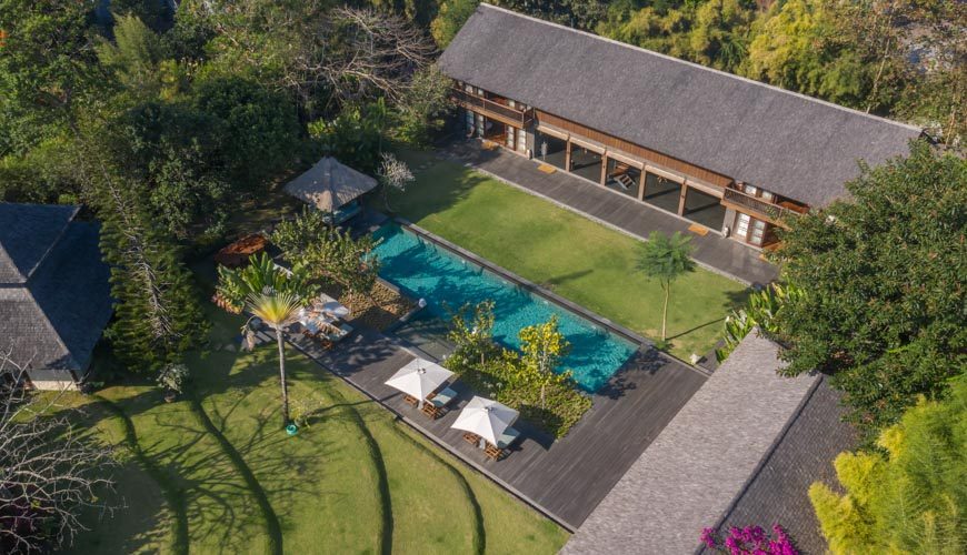Aerial view of Amita Villa's pool, lawn, and pavilions in the rice fields