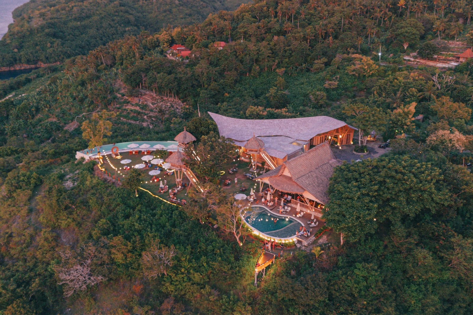 Aerial view at dusk of the bamboo pavilions and pools of Amok Sunset on Nusa Penida, Bali