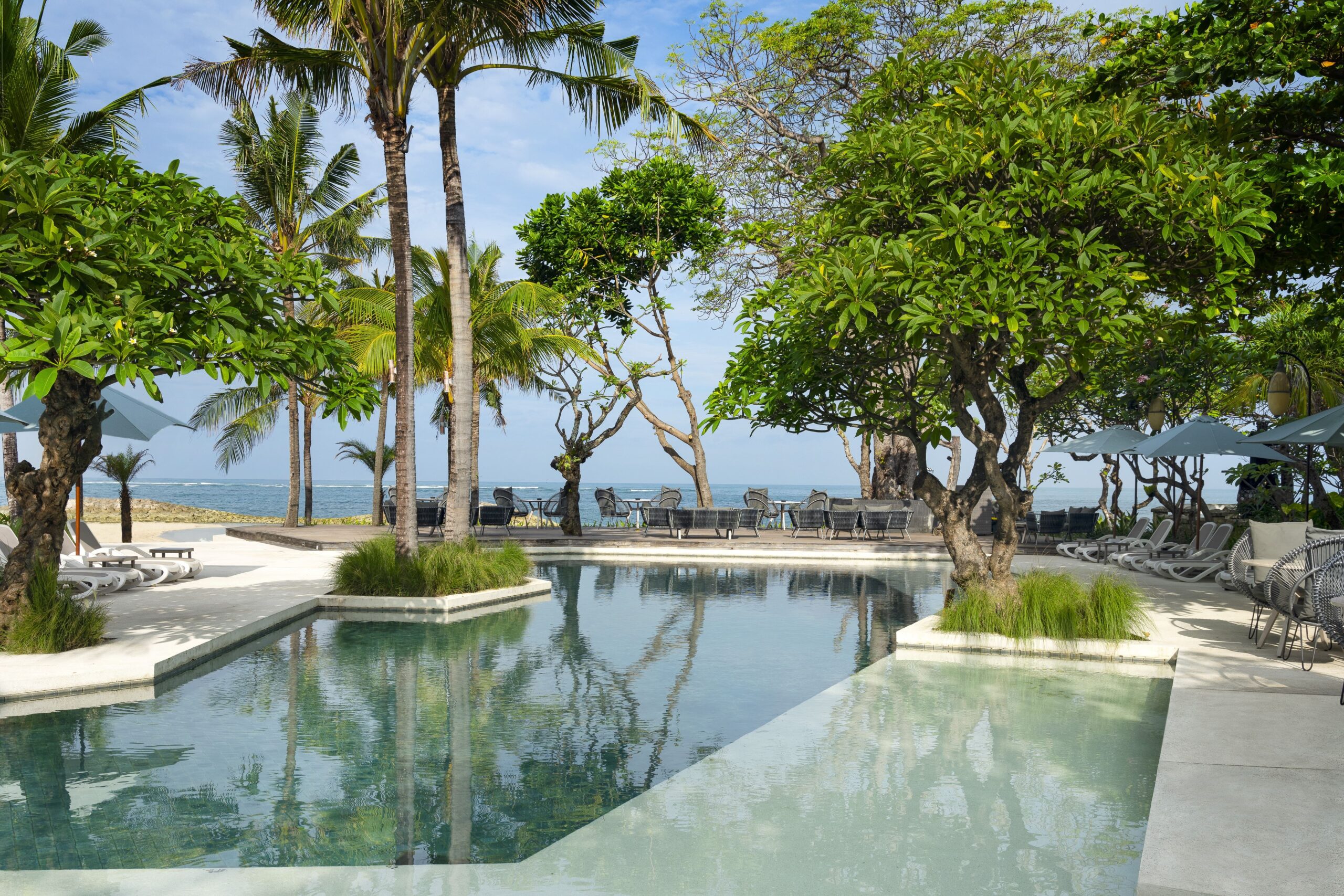 Resort pool with tropical landscaping and ocean view at The Anvaya Beach Resort Bali, Kuta