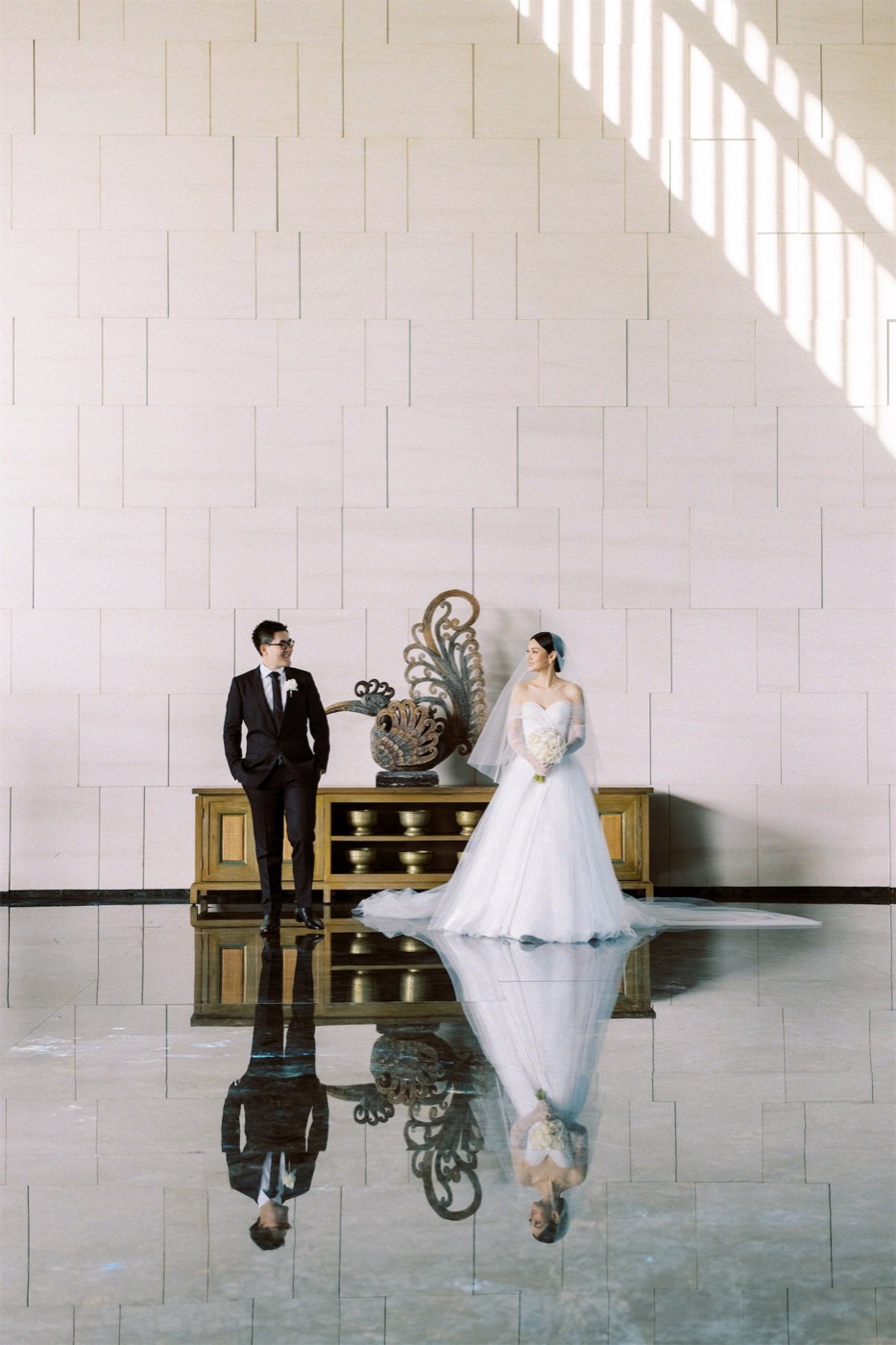 A couple in the carved stone lobby of The Apurva Kempinski Bali, Nusa Dua