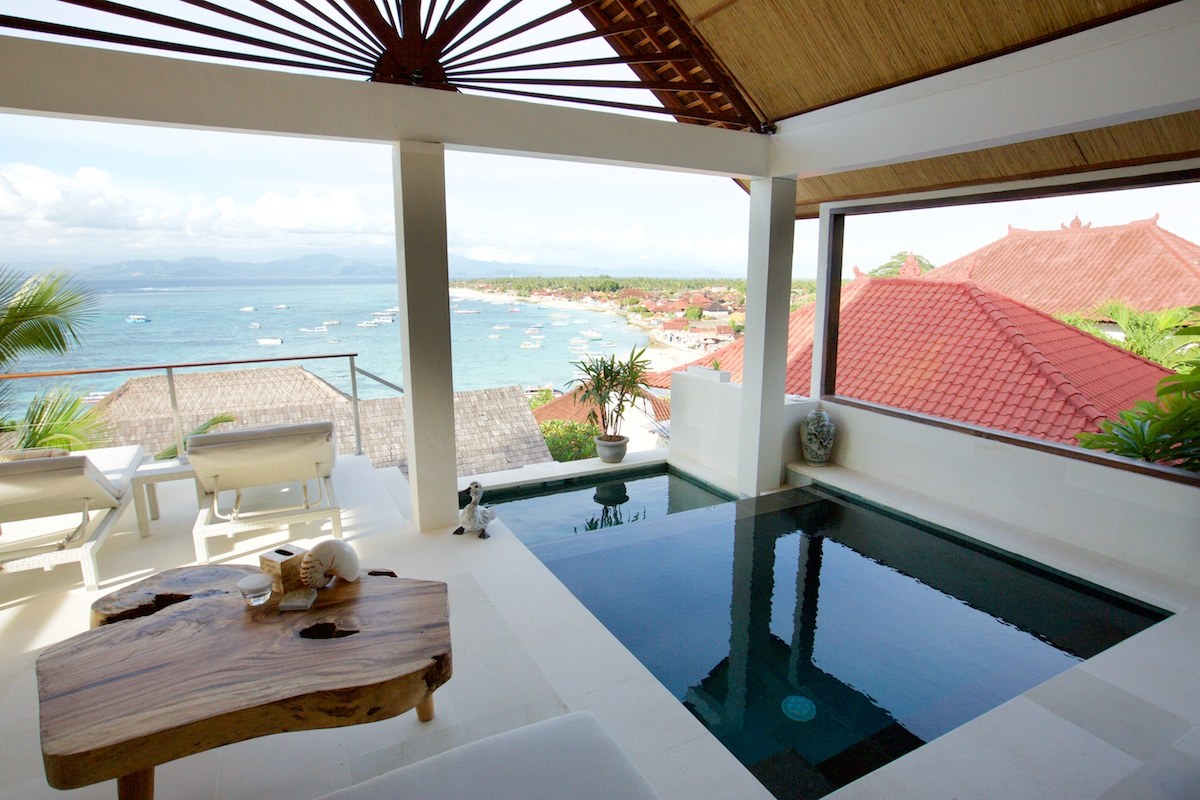 Villa living room opening onto a private pool with the bay beyond at Aqua Nusa Villas, Nusa Lembongan, Bali