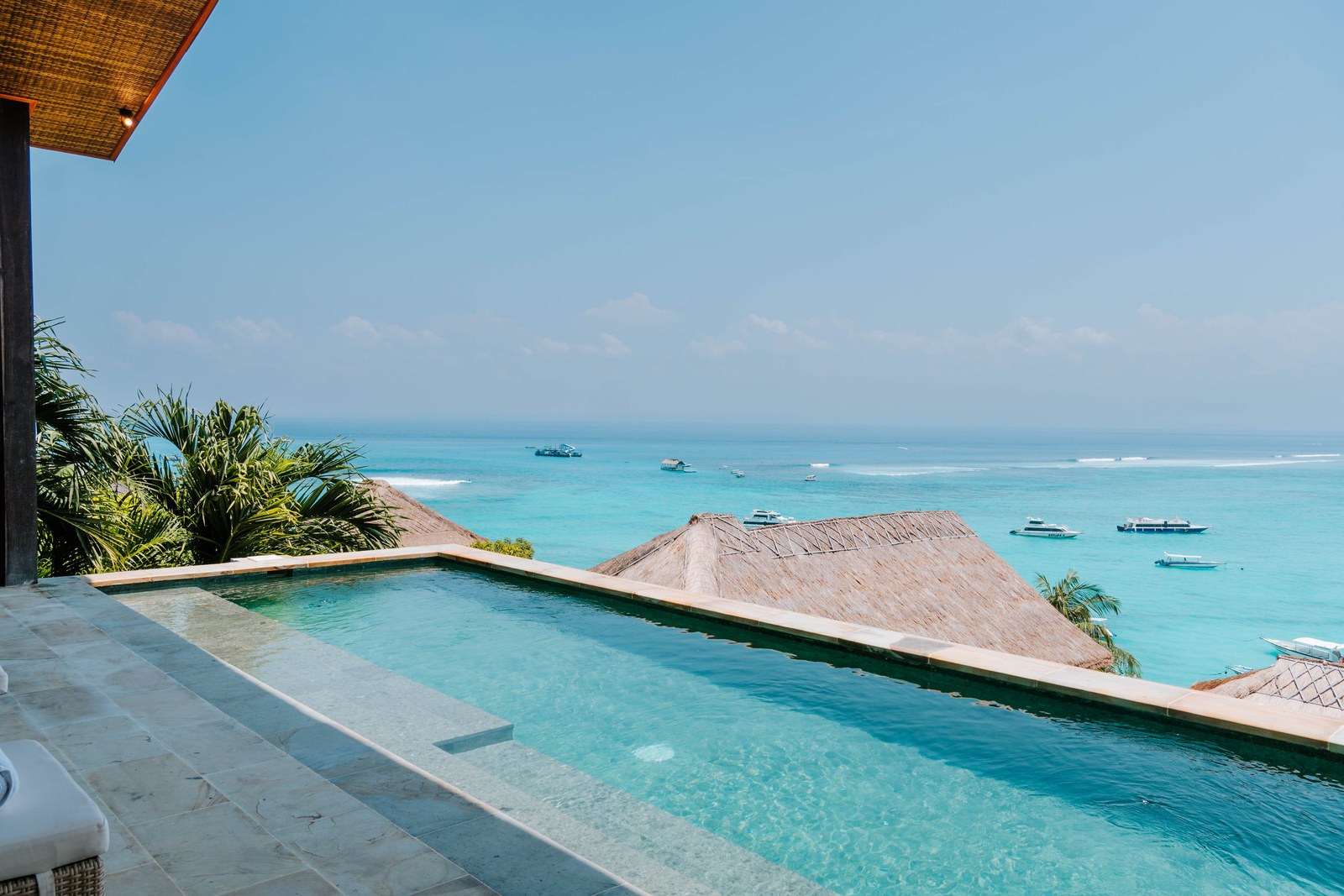 Infinity pool looking over the reef and moored boats at Aqua Nusa Villas above Jungut Batu, Nusa Lembongan, Bali
