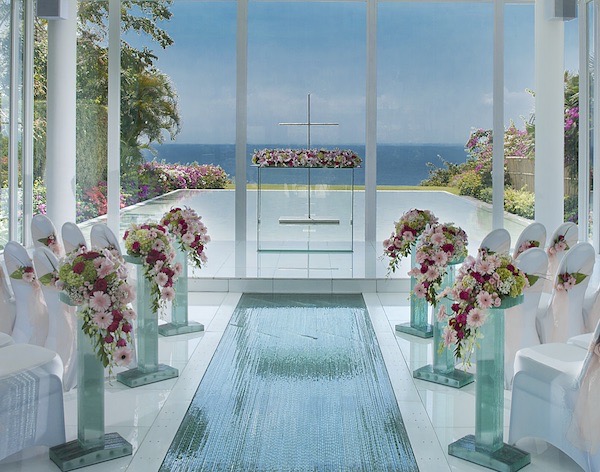Interior of Astina Chapel at AYANA Resort Bali, glass walls opening toward the ocean horizon