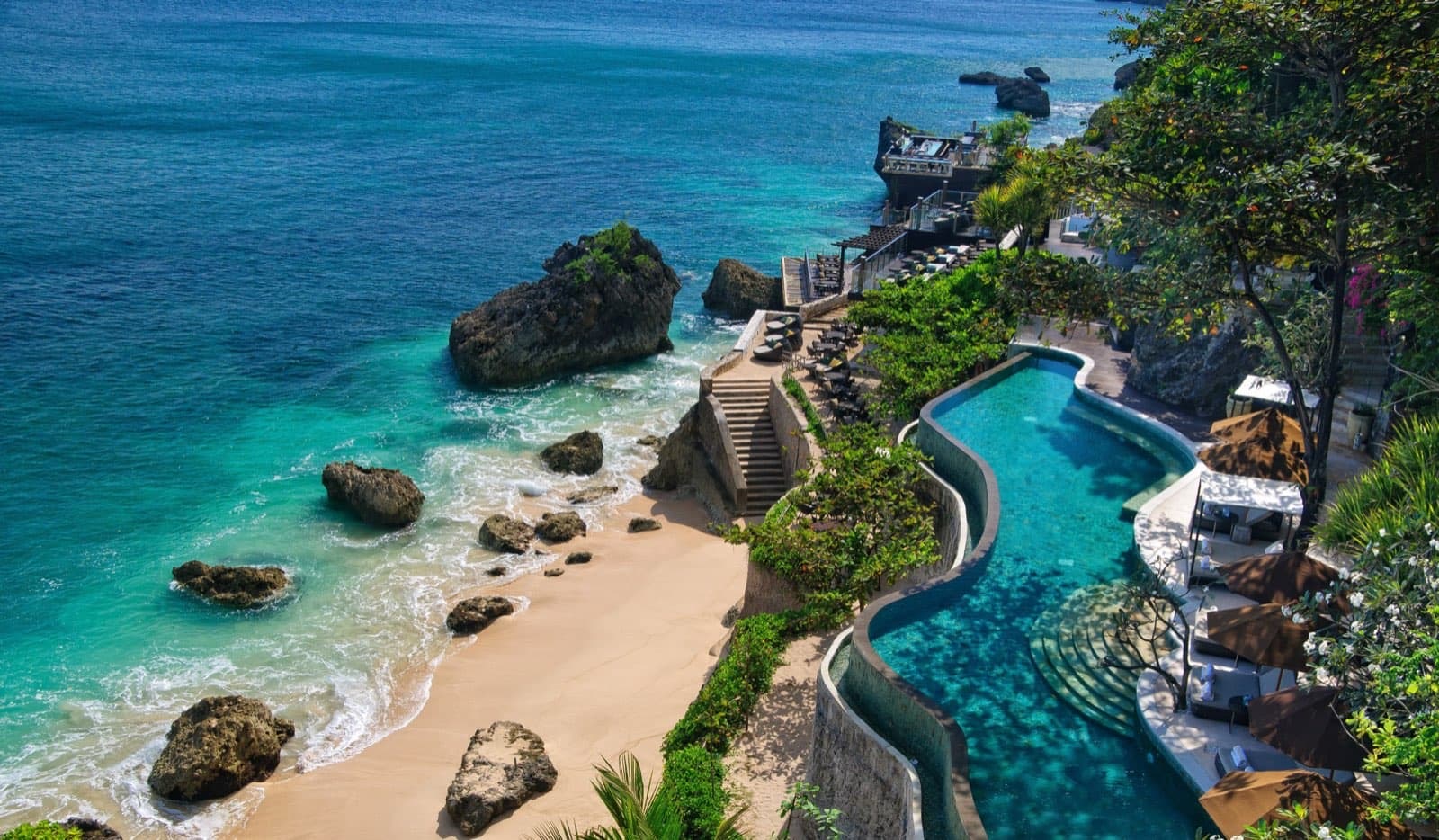 AYANA Estate's clifftop pool and private beach above the turquoise water of Jimbaran Bay, Bali