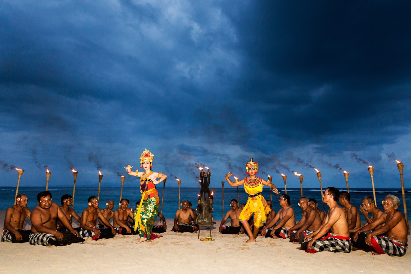 Balinese torch-lit dancers performing on the beach at dusk at Ayodya Resort Bali, Nusa Dua