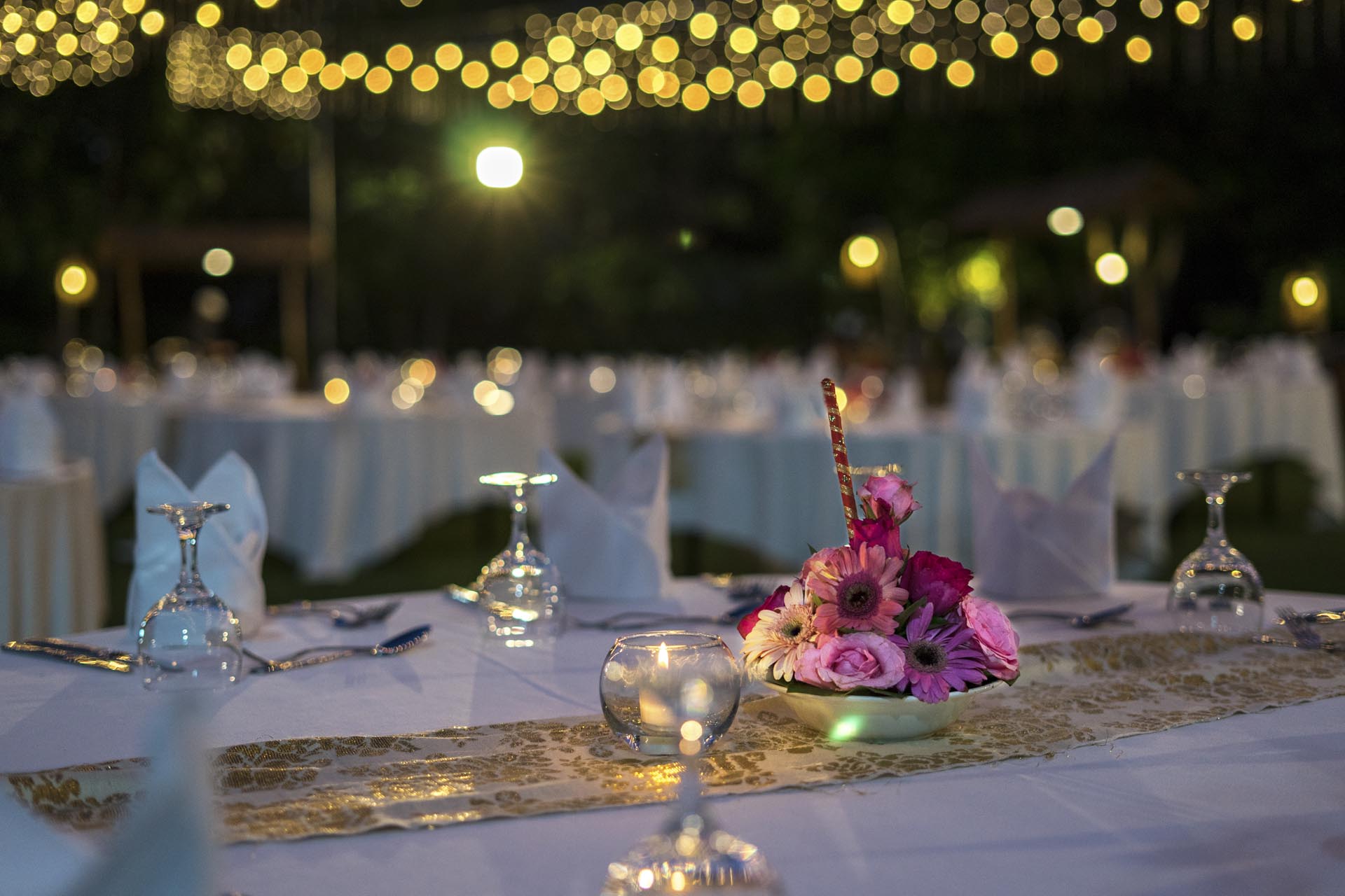 Candlelit reception table detail under strung lights at Ayodya Resort Bali, Nusa Dua