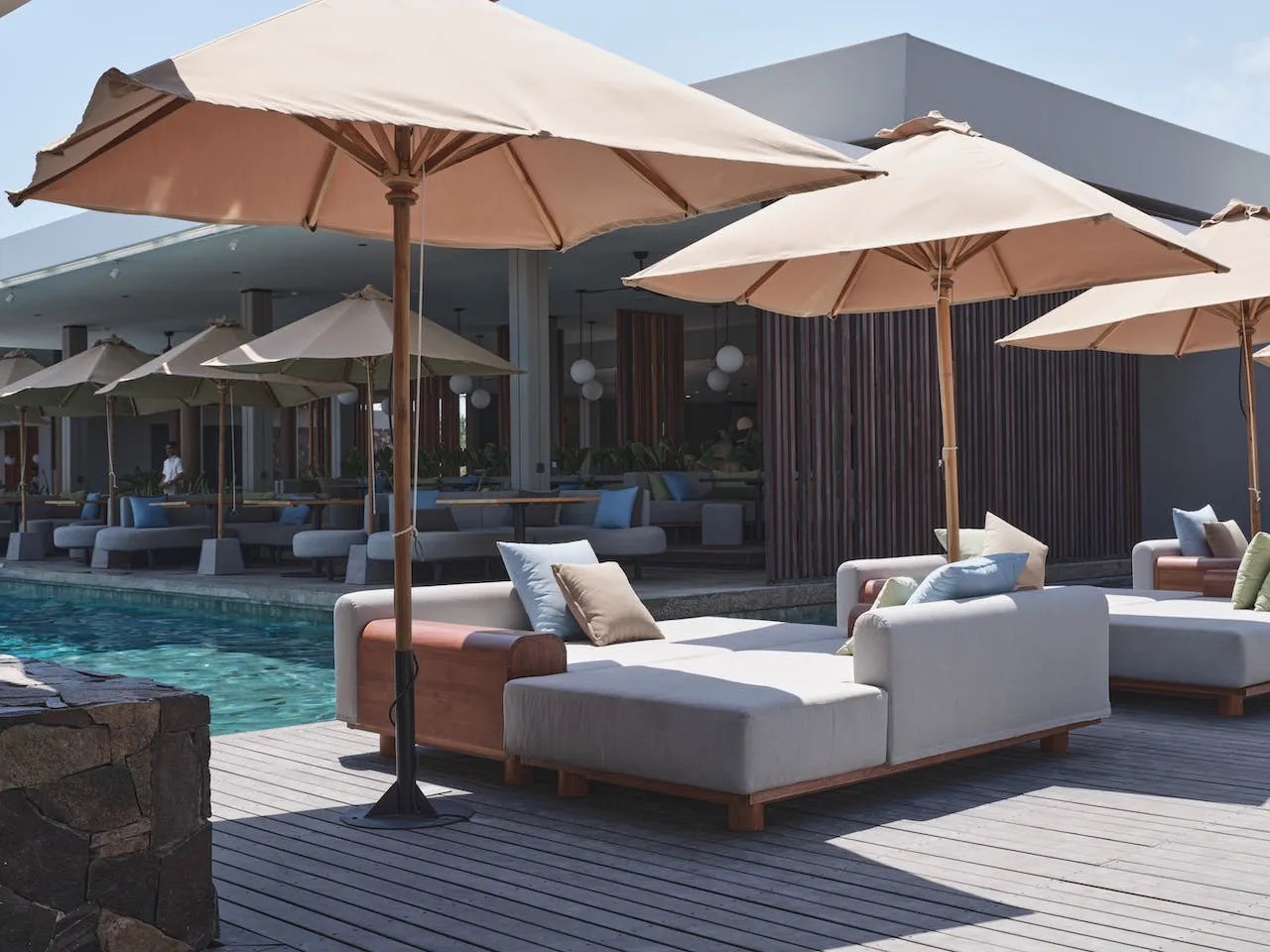 Parasols and day beds on the timber deck beside the infinity pool at BASK Gili Meno, Gili Meno