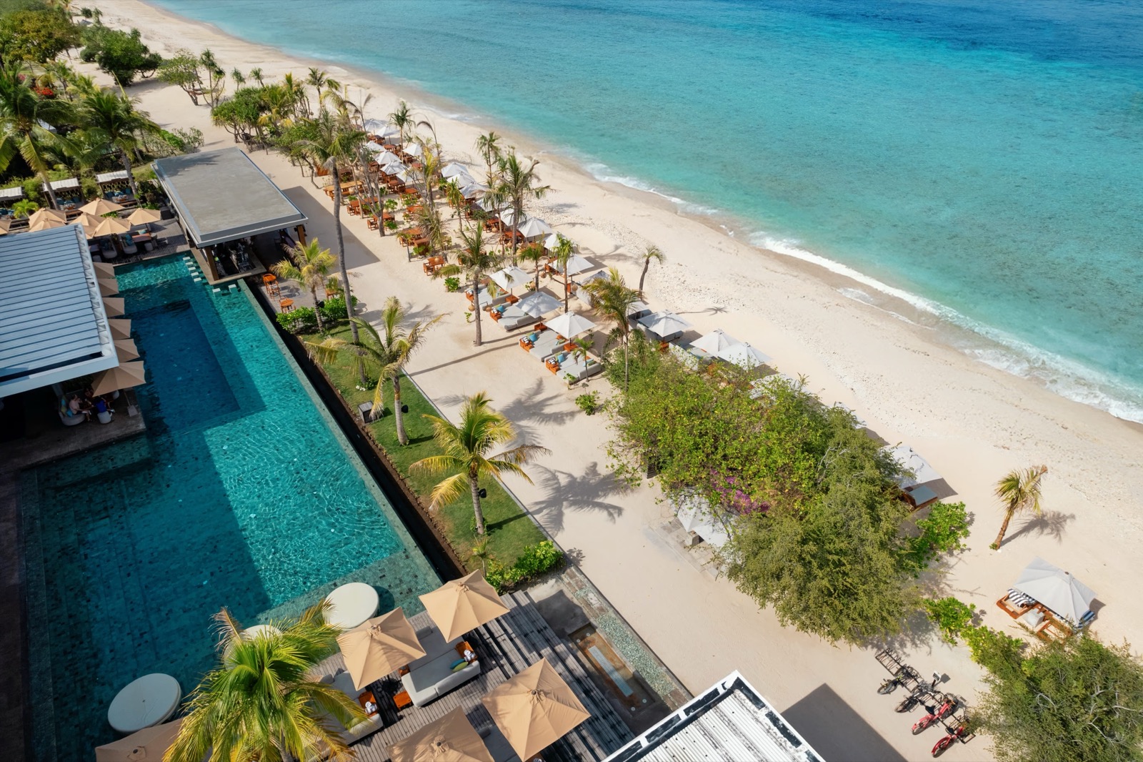 Aerial view of the beach club, long infinity pool and white-sand beach at BASK Gili Meno, on Gili Meno off Lombok