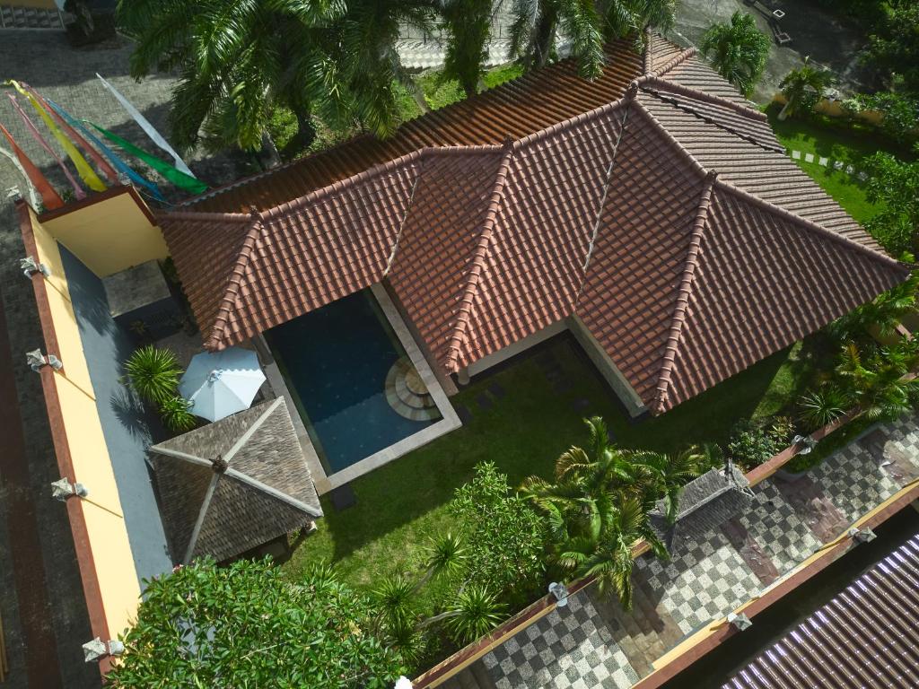 Aerial view of a tiled-roof villa and its plunge pool set in the garden at The Beverly Hills Bali