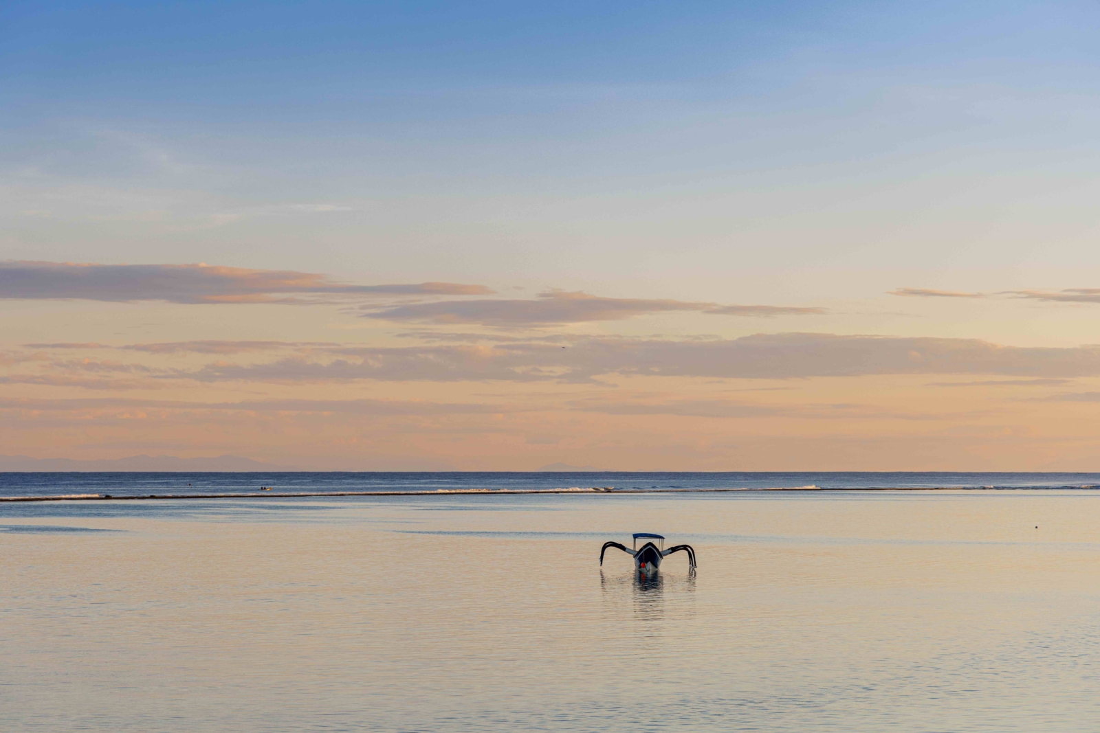 Outrigger boat on the flat water off Karoso Beach at sunset, Cap Karoso, Sumba