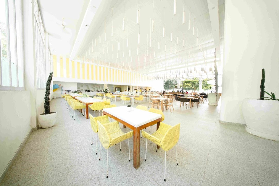 High-ceilinged restaurant hall set with long tables at Caspla Beach Club Nusa Penida, Bali