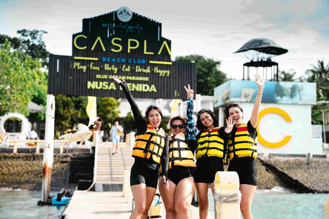 Guests on the private pier under the Caspla Beach Club sign at Nusa Penida, Bali