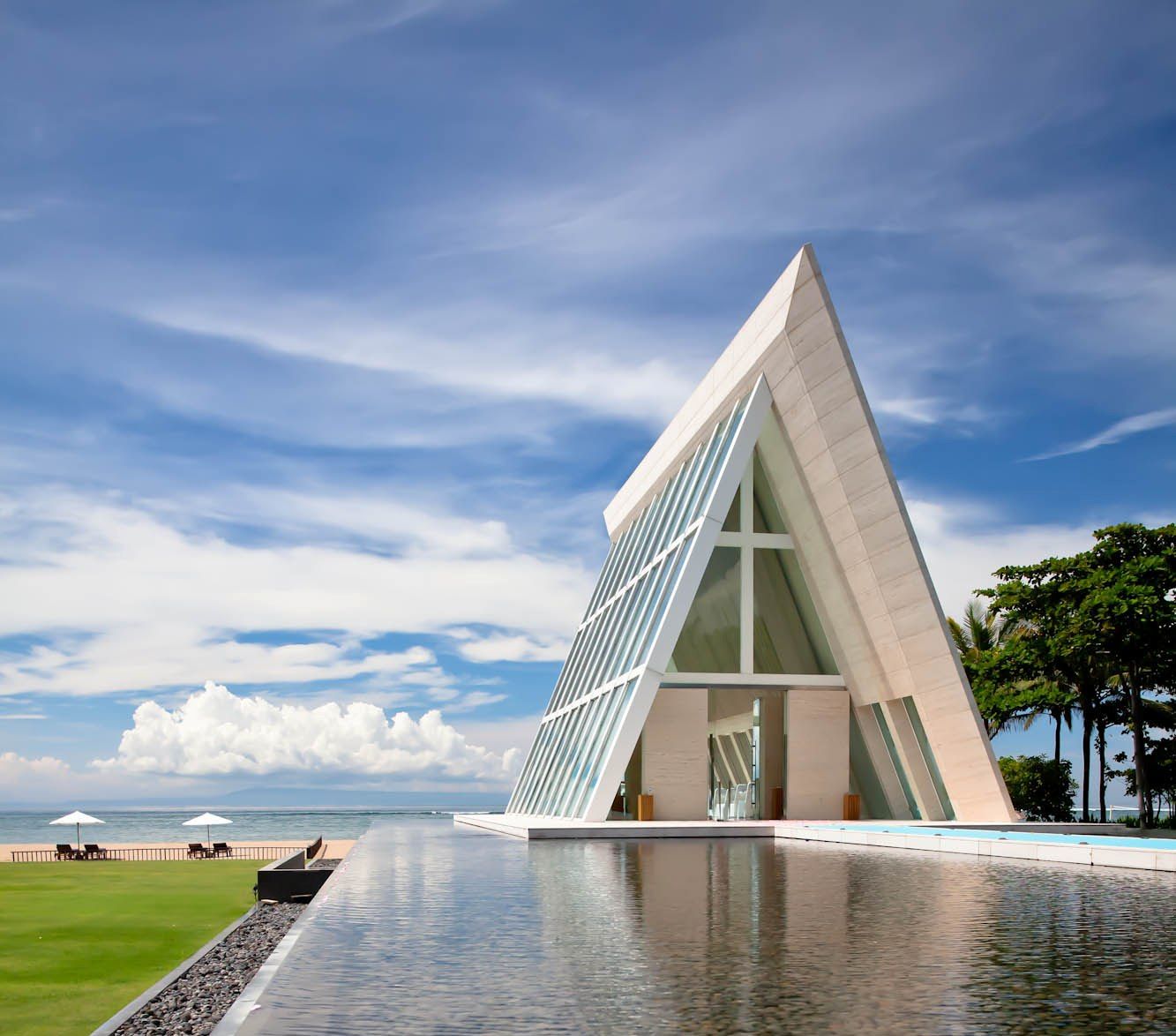 A beachfront ceremony set on the lawn with the ocean behind at Conrad Bali, Tanjung Benoa