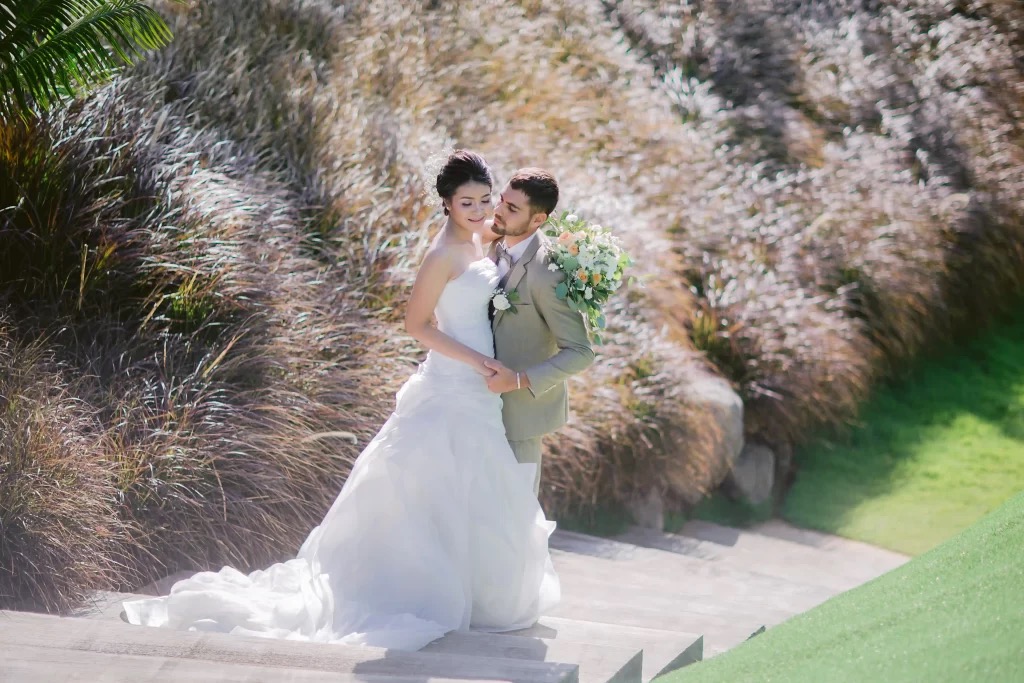 A couple on the ceremony lawn at Cross Bali Breakers with the ocean beyond