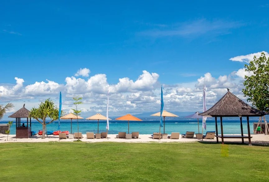 Lawn running down to the sand with umbrellas and a gazebo at d'Nusa Beach Club and Resort, Nusa Lembongan, Bali