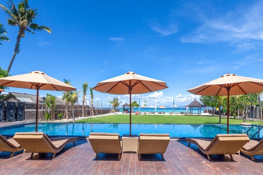 Beachfront pool with loungers and umbrellas at d'Nusa Beach Club and Resort, Nusa Lembongan, Bali