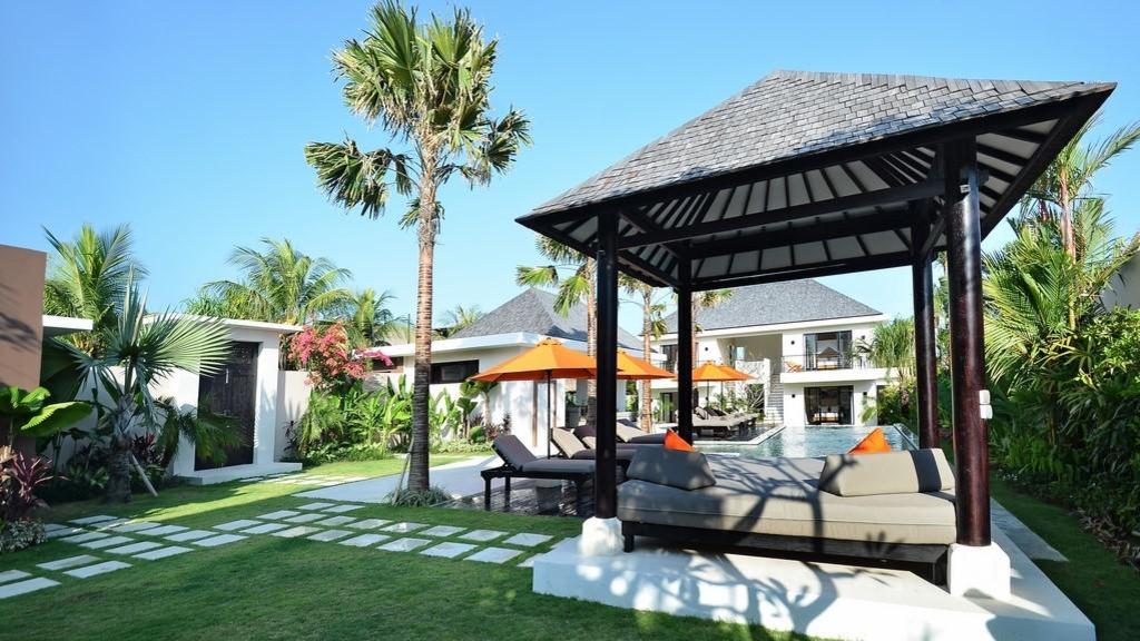 Thatched gazebo and day bed on the garden lawn at Echo Beach Duo Villa Enam