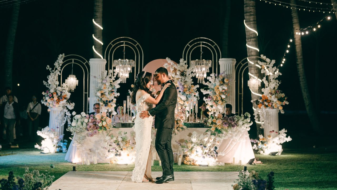 An evening wedding reception on the lawn at 88 Estuary Saba Beach in Gianyar, floral arches and a dance floor under festoon lighting