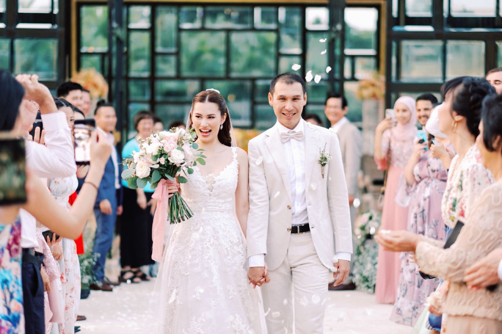 Petal-throwing recessional outside the glass Eternity Chapel at The Mulia, Nusa Dua