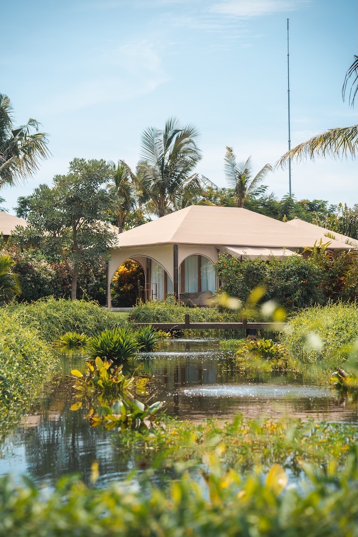 A luxury tented villa beside a lily pond among palms at Glamp Nusa glamping resort, Nusa Dua