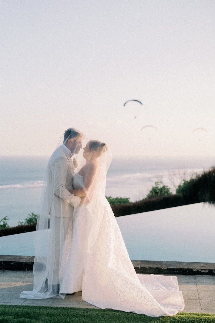 A couple by the clifftop infinity pool overlooking the ocean at Glamp Nusa, Nusa Dua