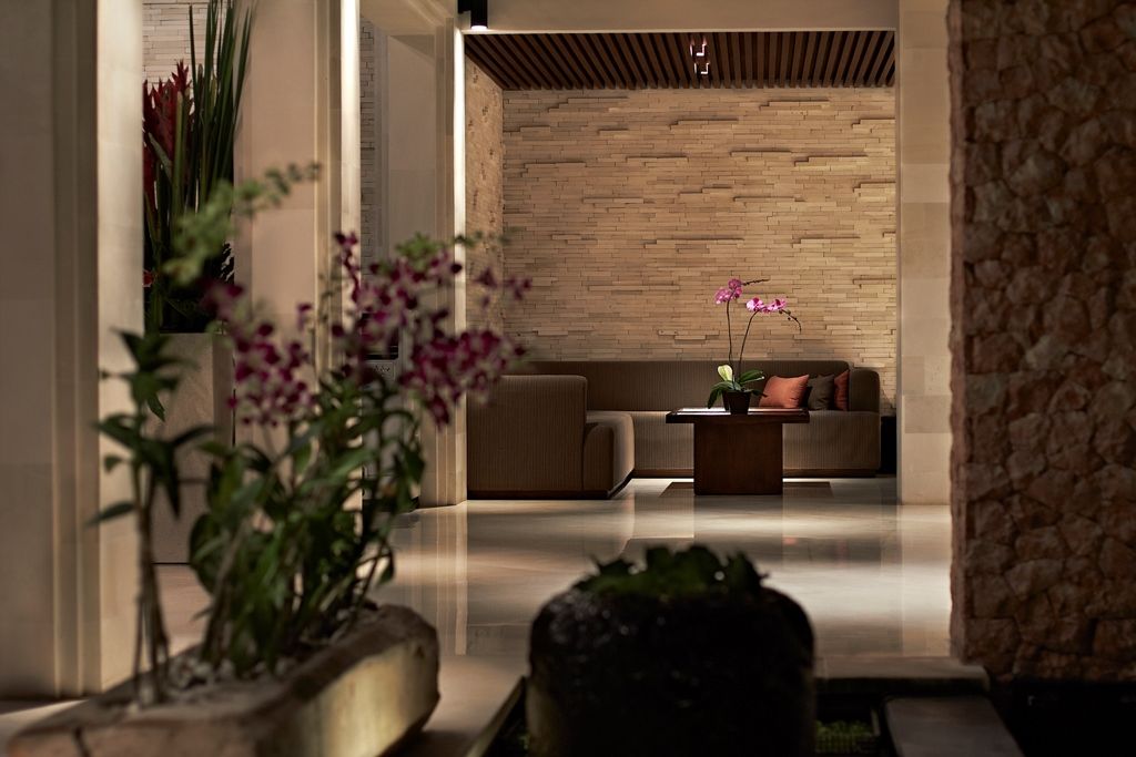 The open Balinese lobby at Griya Santrian, a beachfront resort on Sanur Beach, with timber, thatch, and garden views