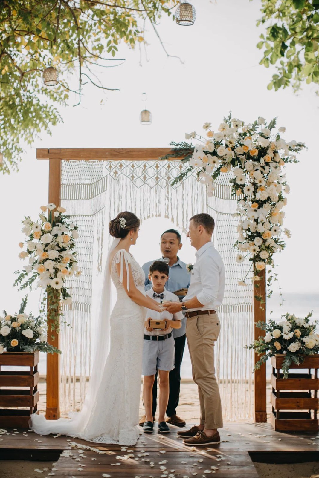 Ceremony under a floral and macrame arch at Hai Tide Beach Resort, Mushroom Bay, Nusa Lembongan, Bali