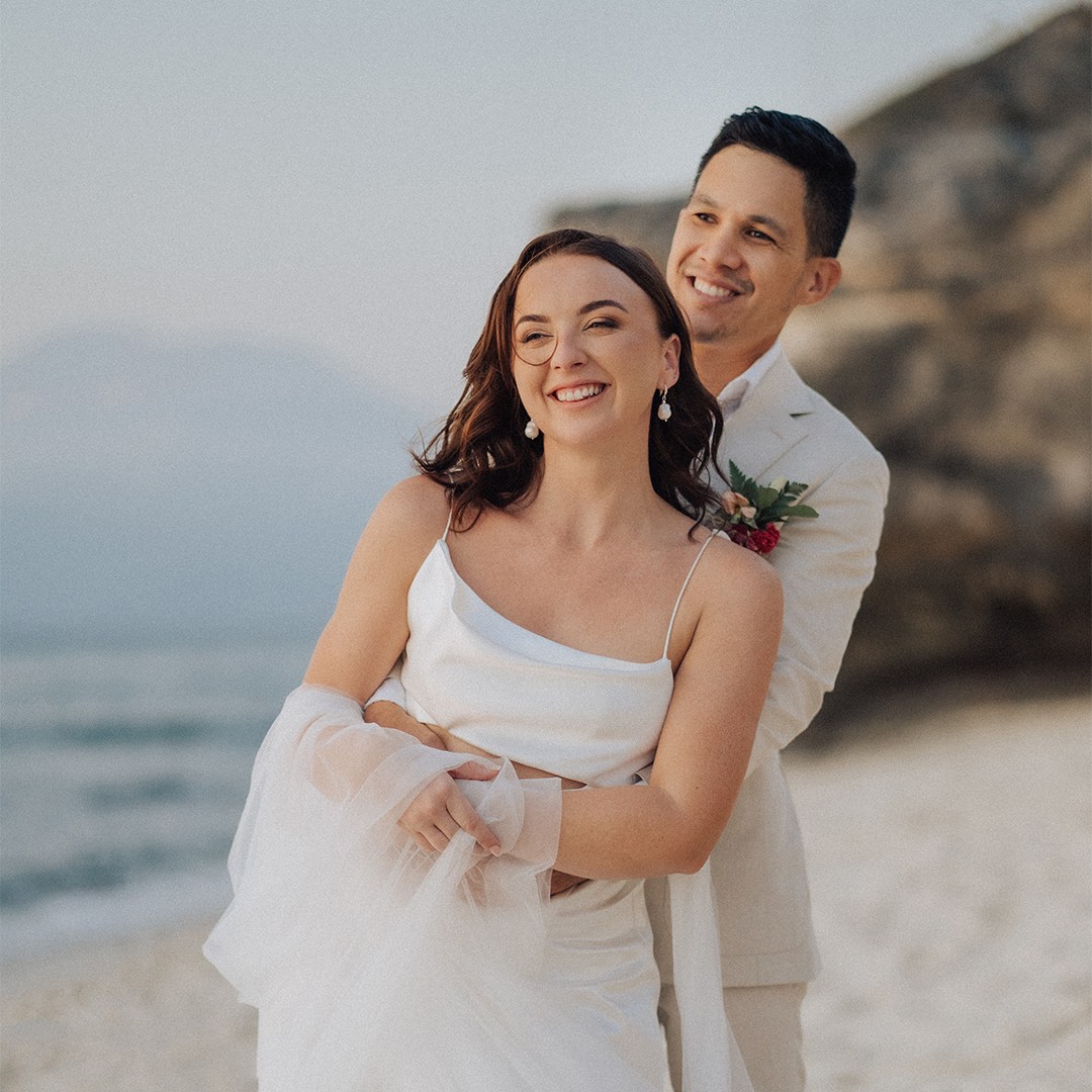 Newlywed portrait on the sand at Mushroom Bay with the headland behind, Hai Tide Beach Resort, Nusa Lembongan, Bali