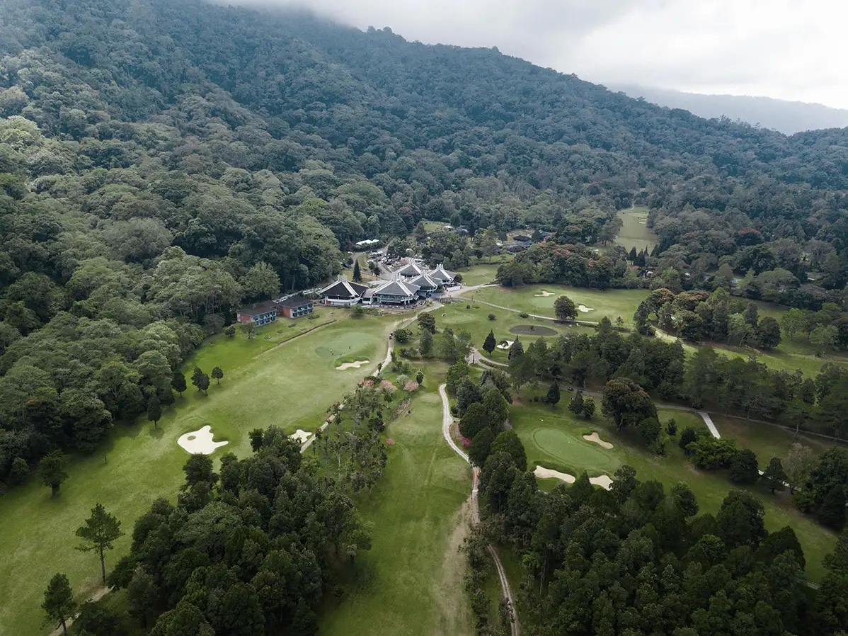 Aerial view of the clubhouse, fairways and forested crater wall at Handara Golf & Resort Bali, Bedugul, Bali