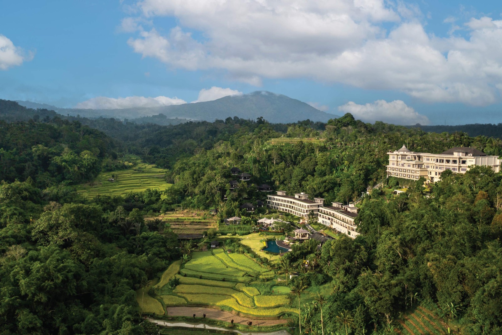 Aerial view of HOMM Saranam Baturiti among rice terraces and rainforest with Mount Batukaru behind, Baturiti, Bali