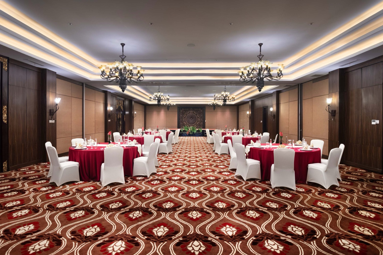 Ballroom set with round tables under chandeliers at HOMM Saranam Baturiti in the Bali highlands