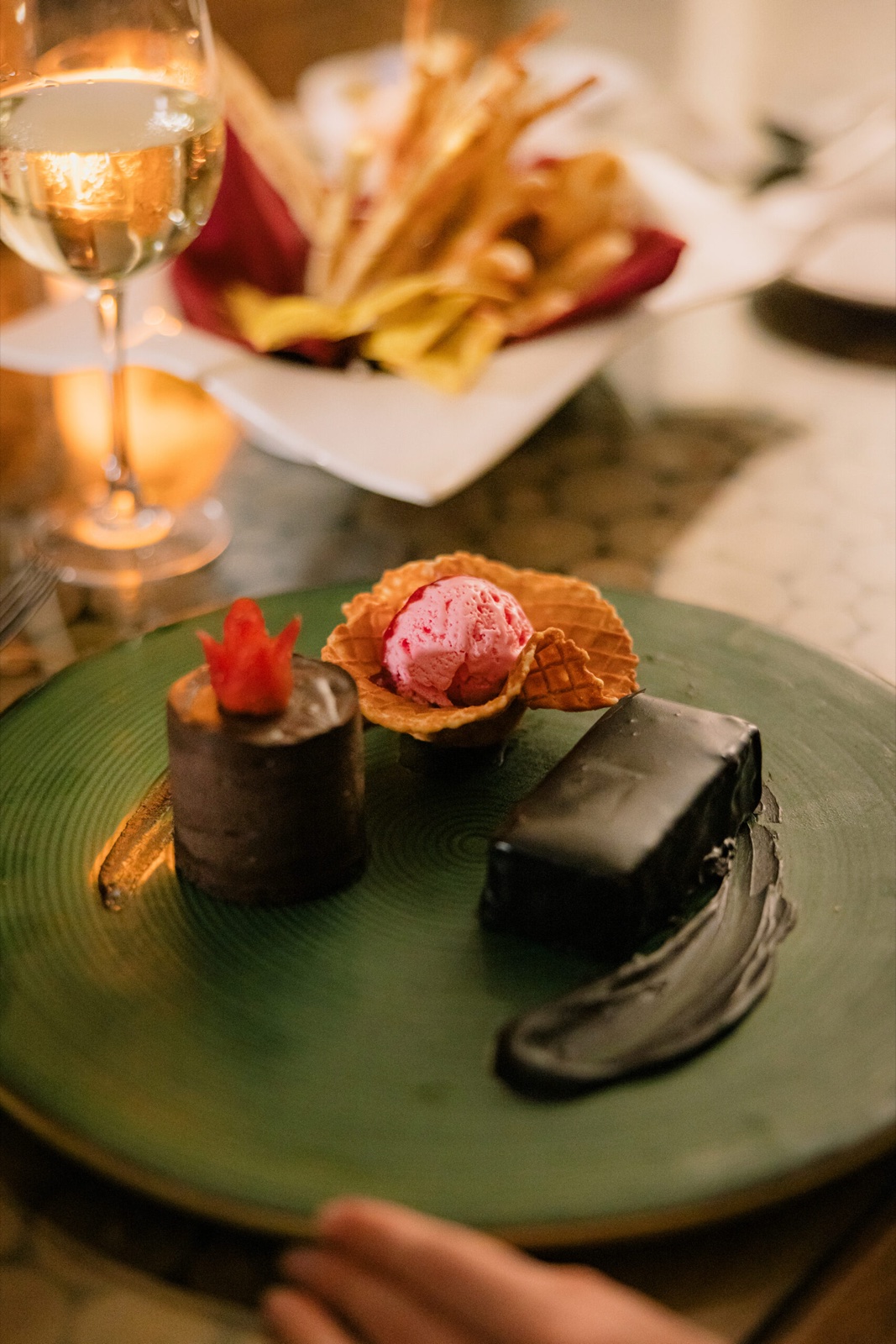 Plated chocolate dessert and a glass of wine at a candlelit dinner at Hotel Ombak Sunset, Gili Trawangan