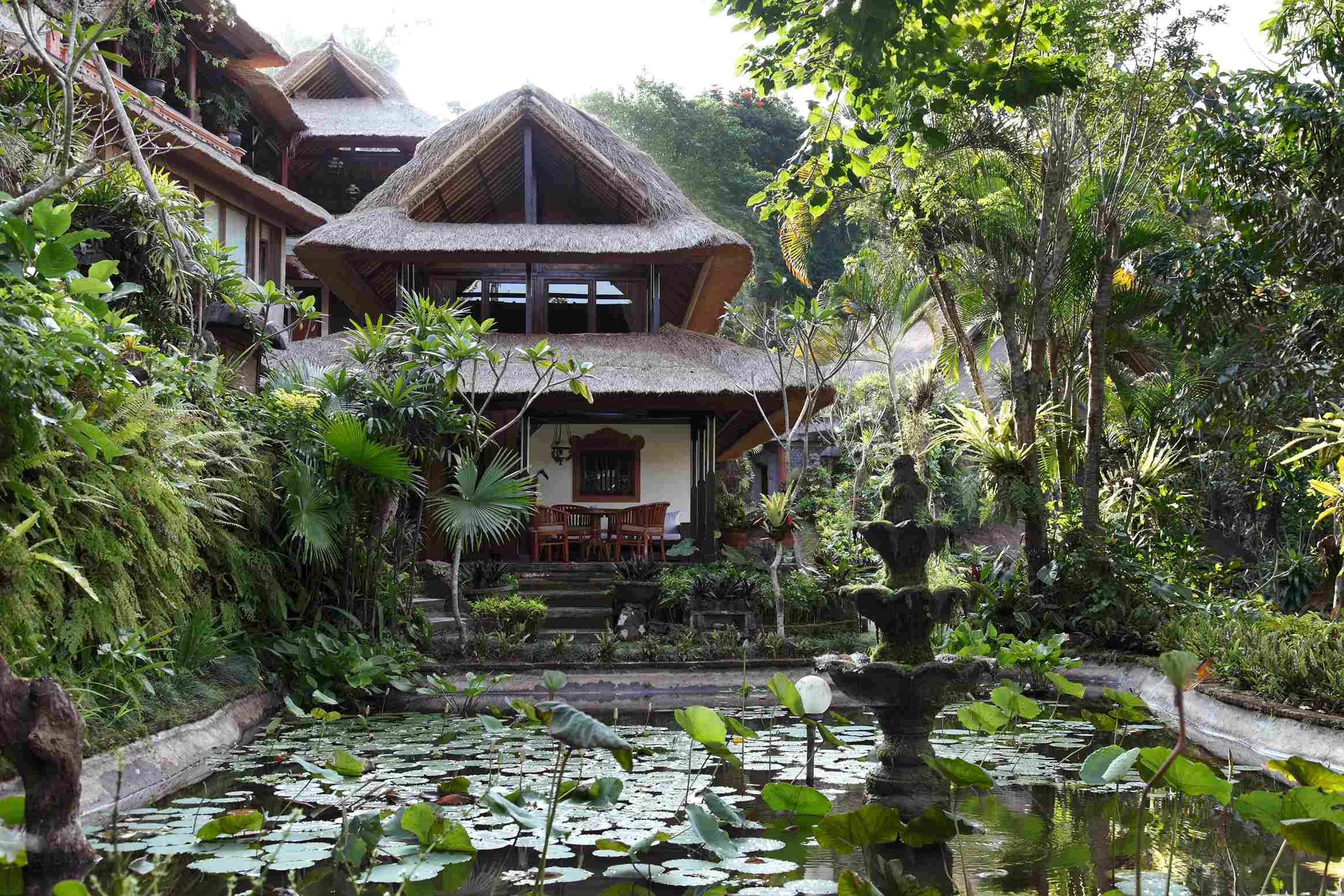 Thatched-roof bungalows above a lotus pond in the terraced gardens of Hotel Tjampuhan & Spa, Ubud