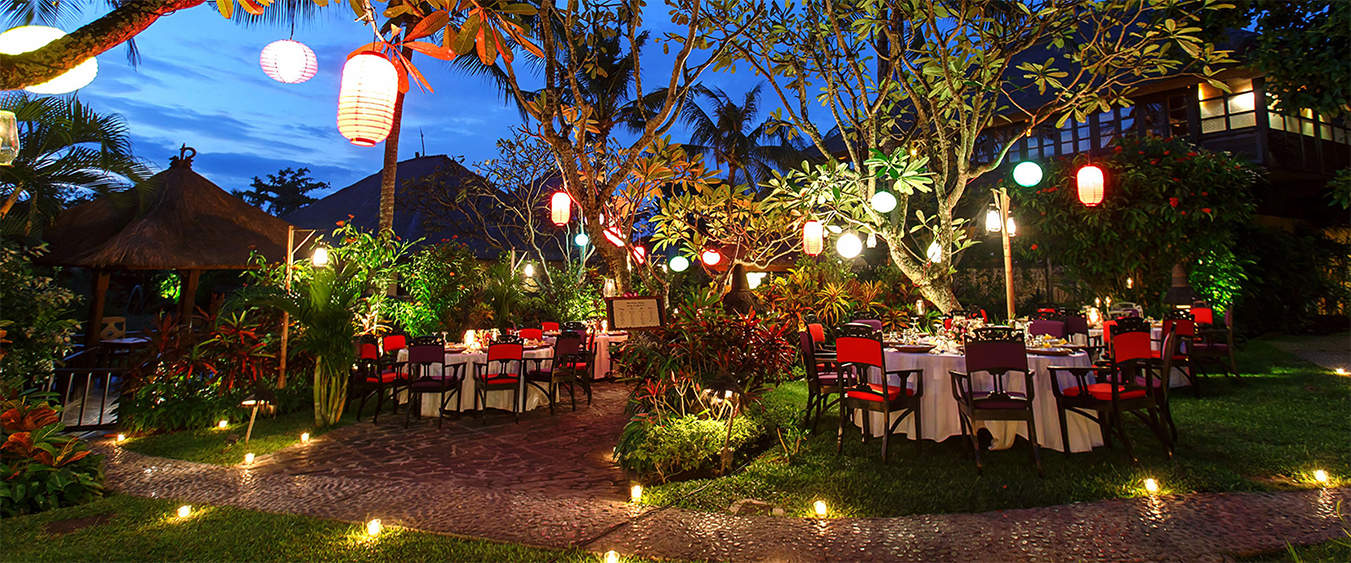 Tropical garden set for an evening reception with paper lanterns and candlelight at Hotel Tugu Bali, Canggu