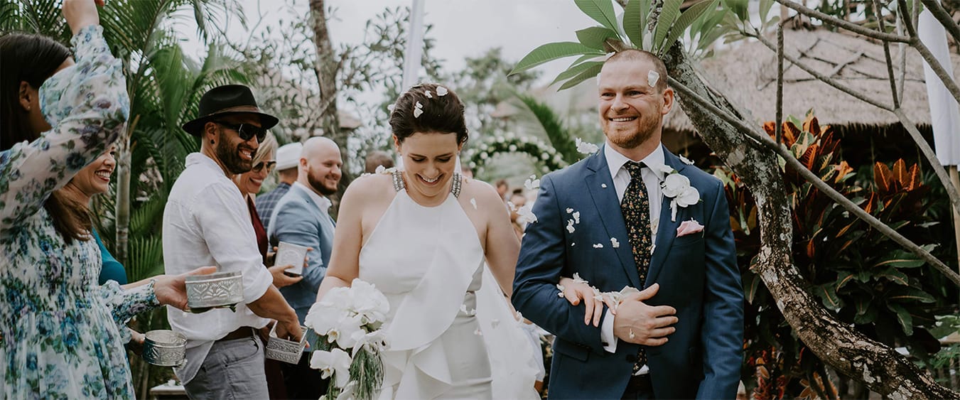 Newlyweds during their ceremony recessional through the tropical garden at Hotel Tugu Bali, Canggu