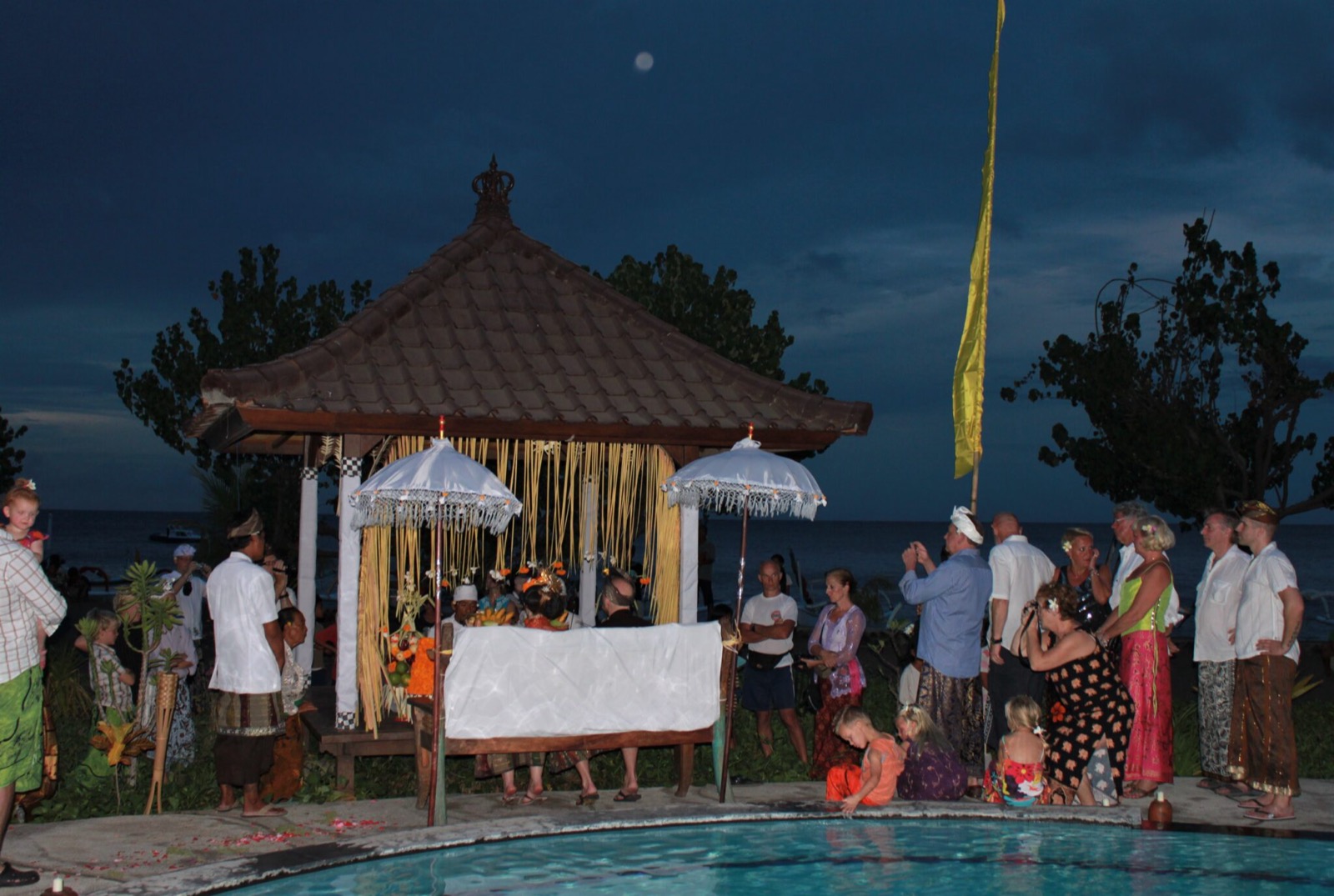 Evening Balinese wedding ceremony under the beachfront bale beside the pool at Hotel Uyah Amed & Spa Resort in Amed, east Bali
