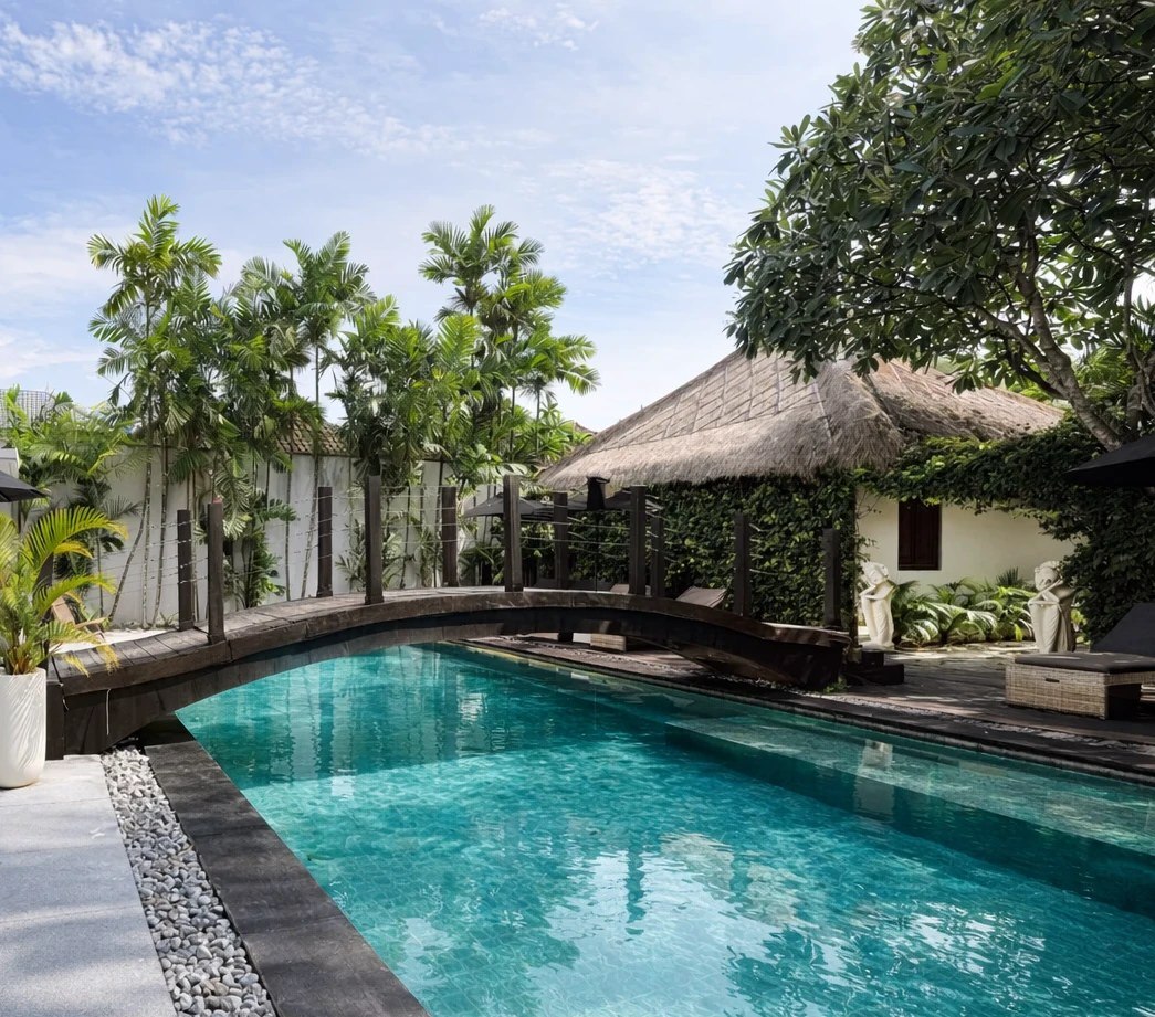 Garden pool framed by thatched roofs and palms at Indiana Kenanga, Nusa Lembongan, Bali