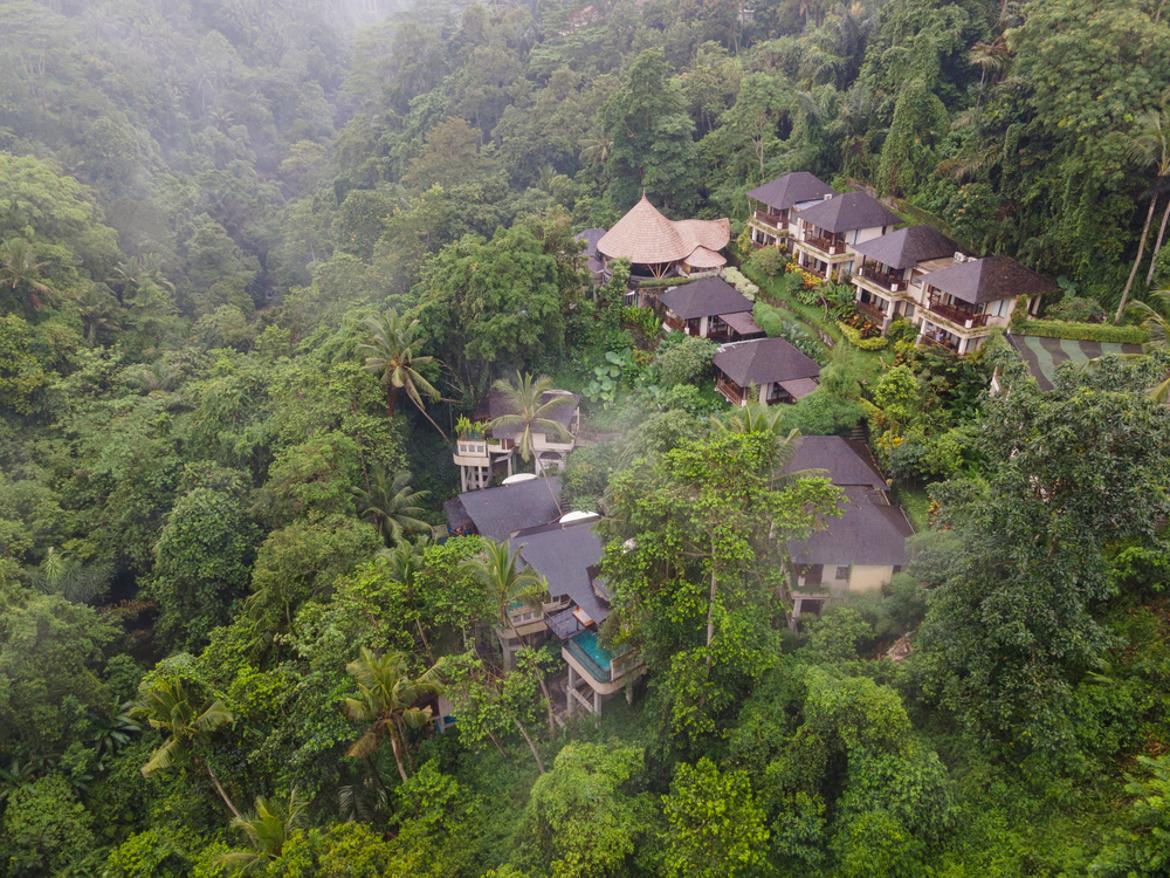 Aerial view of Jannata Resort nestled in the jungle valley with villas and infinity pool, Ubud