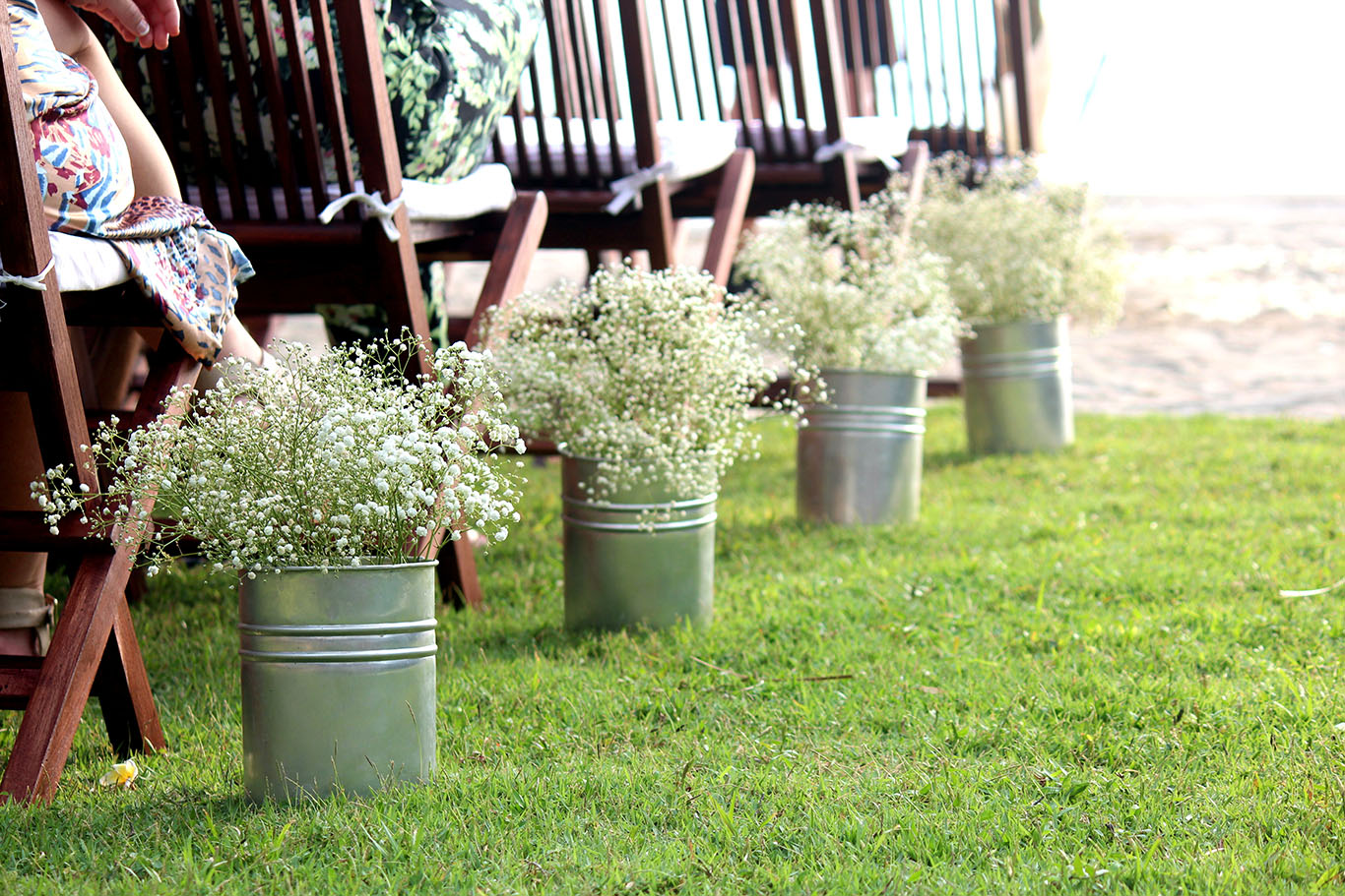 Buckets of gypsophila lining the ceremony aisle on the lawn at Jeeva Klui Resort, Lombok