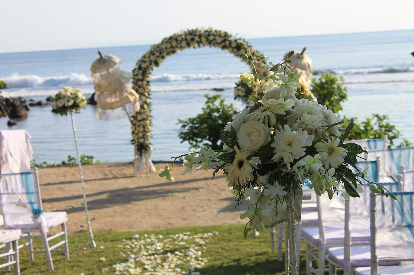 White floral arch and traditional parasols at the water's edge with the ceremony aisle behind, Jeeva Klui Resort, Klui Beach