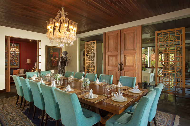 Grand indoor dining room at Jeeva Saba set for guests, with chandelier and carved timber doors